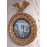 A 61.5cm diameter Regency gilt framed and ebony border convex wall mirror with damaged eagle pattern