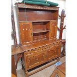 A 1.37m early 20th Century polished oak two part dresser with central shelves, flanking panelled