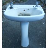 A pedestal sink with taps