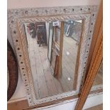 A 54cm wide 20th Century painted wood framed bevelled oblong wall mirror with pierced border