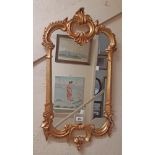 A 41cm reproduction ornate gilt resin framed Rococo style wall mirror with shaped plate
