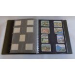 A green ring bound album containing sets of corner mounted cigarette cards, including Churchman