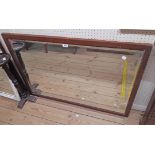 A 1.06m wide stained walnut framed bevelled oblong wall mirror