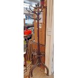 An early 20th Century stained bentwood freestanding hat and coat stand with flat back and triple