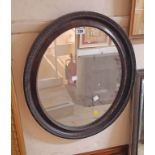A 50cm wide 1920s wood grained framed oval wall mirror