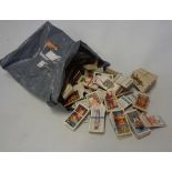 A bag containing a collection of loose cigarette cards, including John Player Uniforms of the