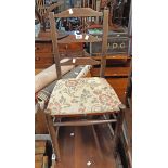An early 20th Century stained wood framed ladder back bedroom chair with upholstered seat