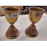 A pair of brass goblets with copper friezes of battle scenes