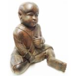 A large carved wooden figure of an Oriental boy