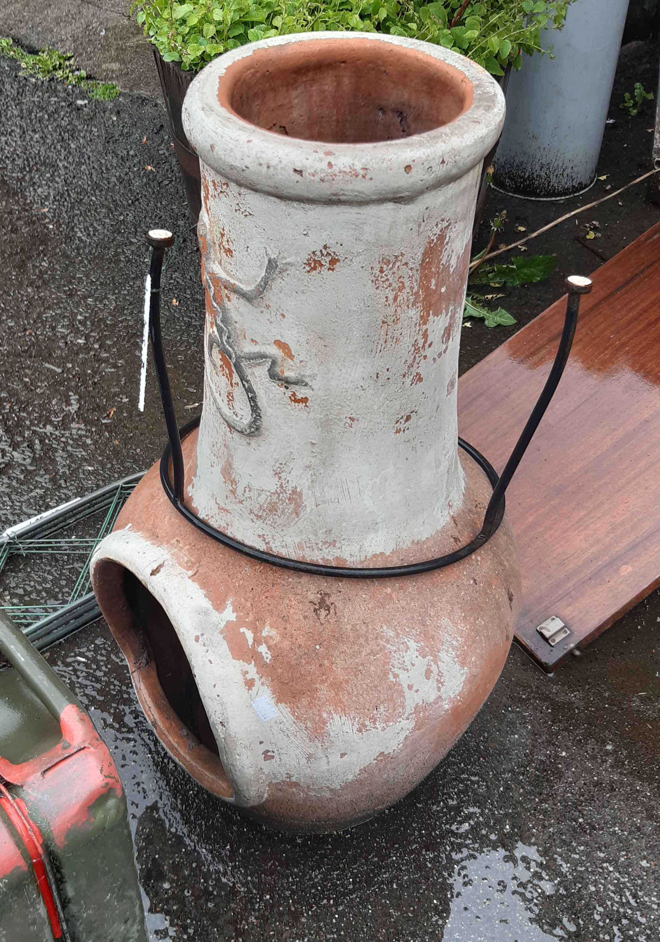 An 83cm high terracotta chiminea with lizard decoration and metal stand