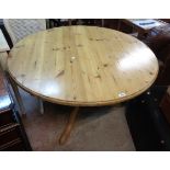 A 1.22m diameter 20th Century varnished pine pedestal dining table, set on massive turned pillar and