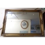 A reproduction ornate gilt framed bevelled oblong wall mirror - 1.04m X 74cm