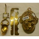 A brass scorpion pattern spoon, a military button stick, and a wall mask