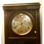 A mid 20th Century stained oak longcase clock with Arabic numerals to dial, glazed door panel and