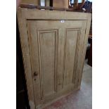 A 92cm antique stripped pine larder cupboard with painted shelves enclosed by a panelled door - wear