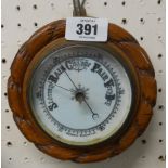 A 15.5cm diameter late Victorian oak framed aneroid wall barometer with rope twist border and