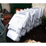 Seven matching Nardi white moulded plastic and slatted folding sun loungers