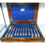 A mahogany cased set of silver plated desert knives and forks with ornate handles - twelve place