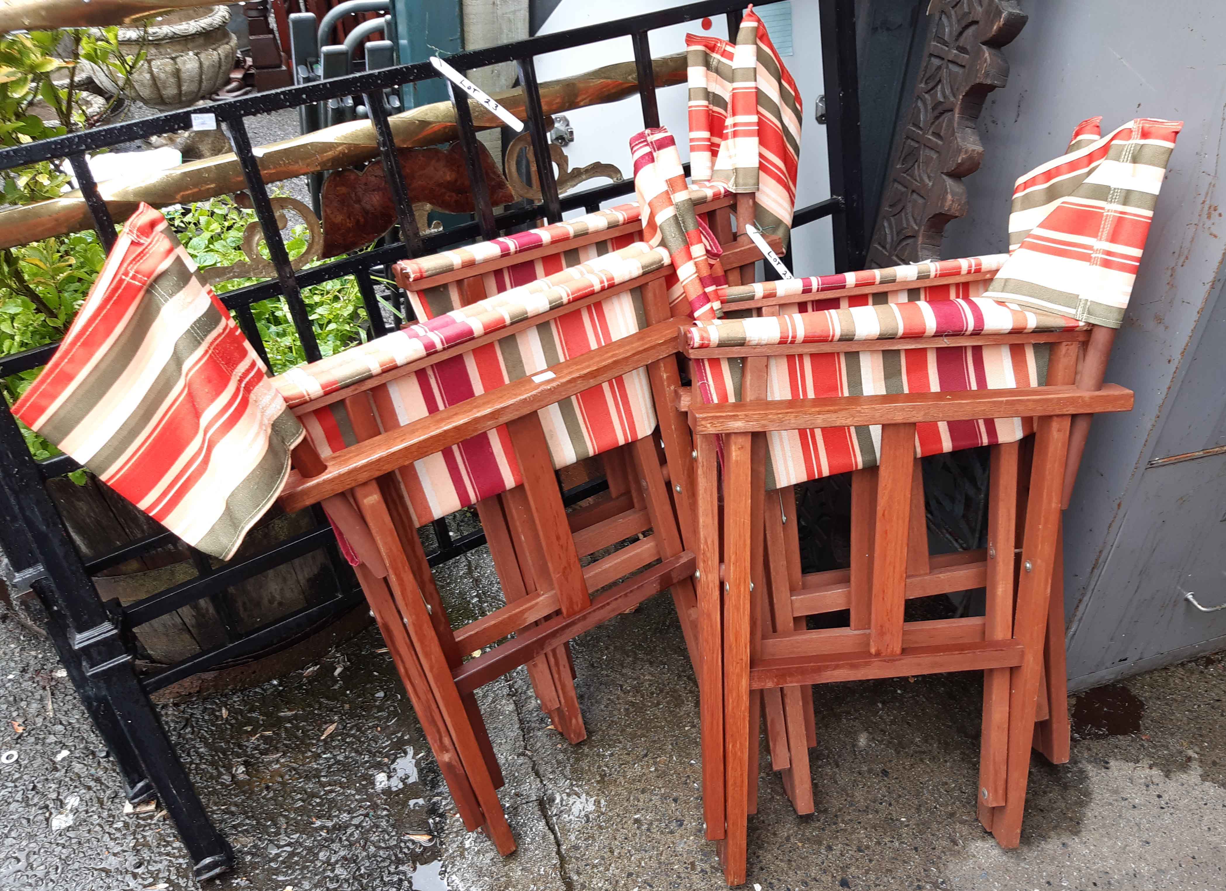 A set of four director's style folding chairs with striped canvas backs and seats