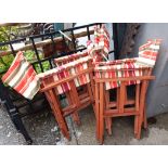 A set of four director's style folding chairs with striped canvas backs and seats