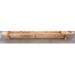 A 3.36m vintage stained pine gymnasium form, set on shaped standard ends - rail stretcher a/f