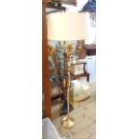 An ornate brass three branch standard lamp with foliage to top and slender reeded pillar with shade