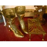 A pair of decorative brass boots - sold with a trivet