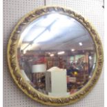 A 73cm diameter old gilt gesso framed bevelled wall mirror