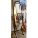 A late 20th Century stained wood framed cheval mirror with oval plate, set on flanking swept legs