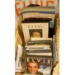 A basket containing assorted Elvis Presley CDs, cassette tapes, magazines, etc.