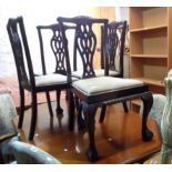 A set of four stained mahogany framed Chippendale style ribbon back dining chairs with drop-in