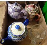 A box containing three ceramic teapots, and a glass pot