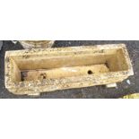 An 87cm cast concrete oblong garden trough with winged figures to corners, set on block bases