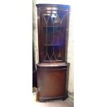 A reproduction mahogany bow front corner cupboard with glazed top and cupboard under, set on bracket