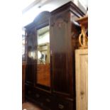 A 1.6m Edwardian stained walnut triple wardrobe with break arch cornice, central bevelled mirror