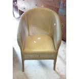 A vintage Lloyd Loom tub chair with original gold sprayed finish and paper label