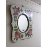 A 47cm decorative painted wood framed wall mirror with oval plate and roses to border