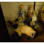 A Royal Doulton model of a Siamese cat, a Lladro girl holding a basket of flowers and three other