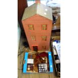 A wooden three storey dolls house and a box containing assorted dolls house furniture