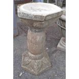 A concrete pedestal bird bath