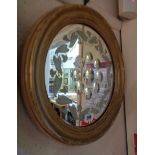 A 37cm diameter antique gilt framed bubble glass wall mirror with etched vine border