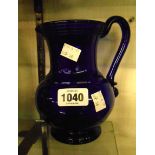 A 19th Century Bristol blue glass jug with applied handle, ribbon trail to rim and raspberry
