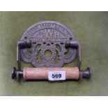 A reproduction cast metal and wood GWR toilet roll holder