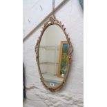 A 66cm vintage gilt cast metal framed oval wall mirror with decorative border