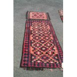 A 20th Century Pakistani kelim with repeat prism design on red ground within a geometric border -