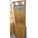 A 65cm reproduction yew corner cabinet with glazed door to top, canted sides and cupboard door