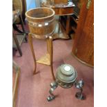 An antique iron mounted cartwheel hub, set in a wrought iron tripod stand - sold with a coopered oak