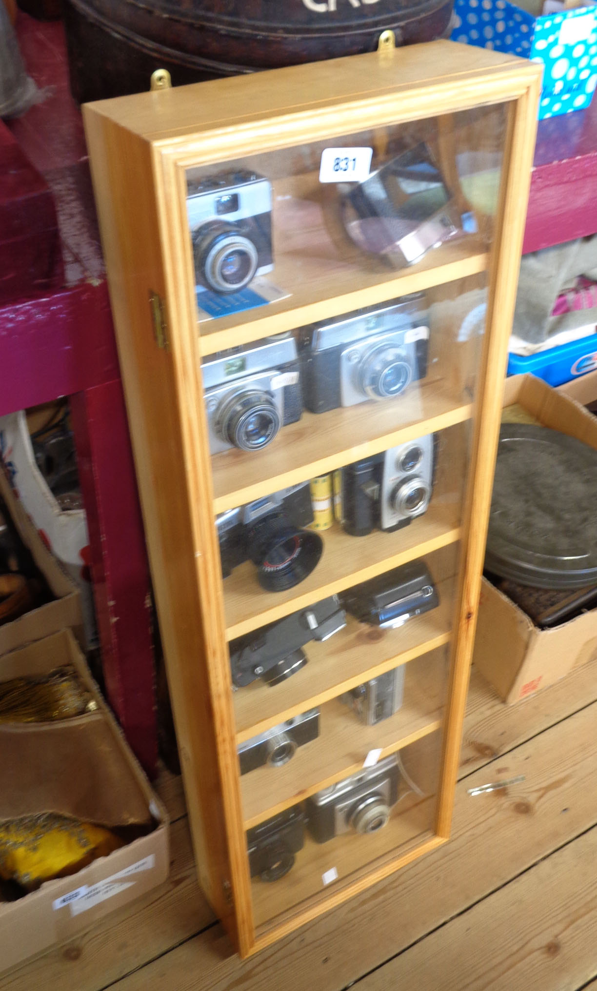 A collector's display case containing twelve assorted vintage cameras including Kodak Brownie Reflex