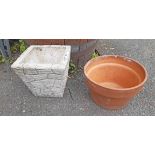 A terracotta plant pot and concrete brick form planter