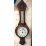 An early 20th Century stained oak cased banjo thermometer/barometer with printed dial, scale and